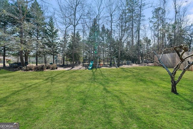 view of yard featuring fence and playground community