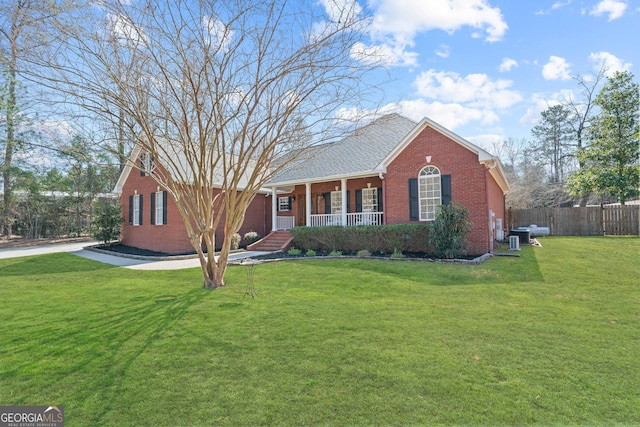 ranch-style house featuring a porch, central air condition unit, brick siding, fence, and a front lawn