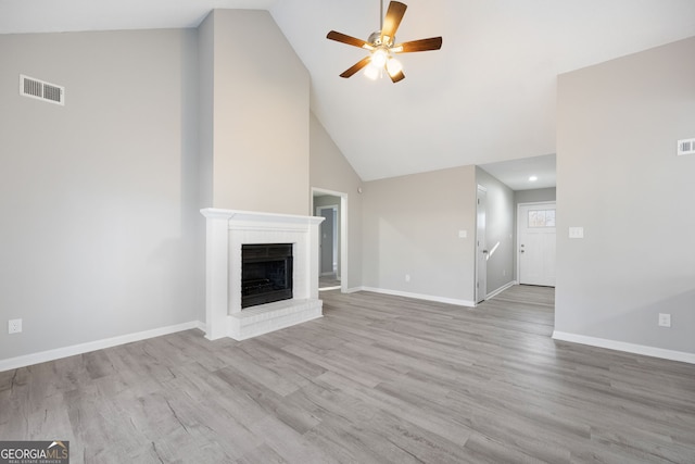 unfurnished living room with visible vents, a brick fireplace, ceiling fan, light wood-type flooring, and baseboards