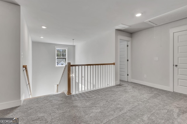 unfurnished room featuring attic access, recessed lighting, carpet flooring, and baseboards