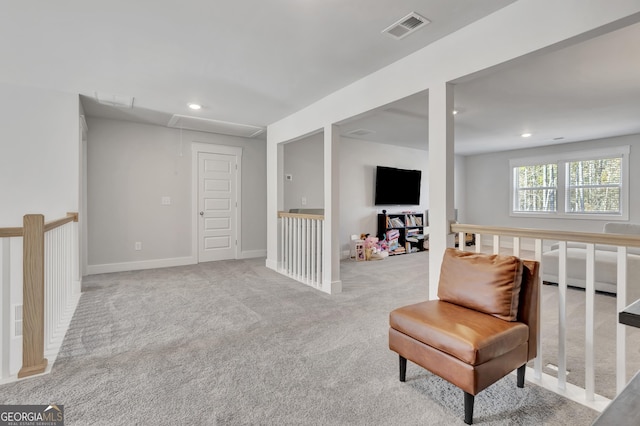 sitting room with attic access, recessed lighting, visible vents, and light carpet