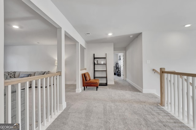 corridor with light carpet, recessed lighting, an upstairs landing, and baseboards