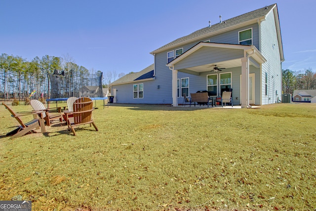 back of property featuring a trampoline, a yard, central AC unit, a patio area, and ceiling fan