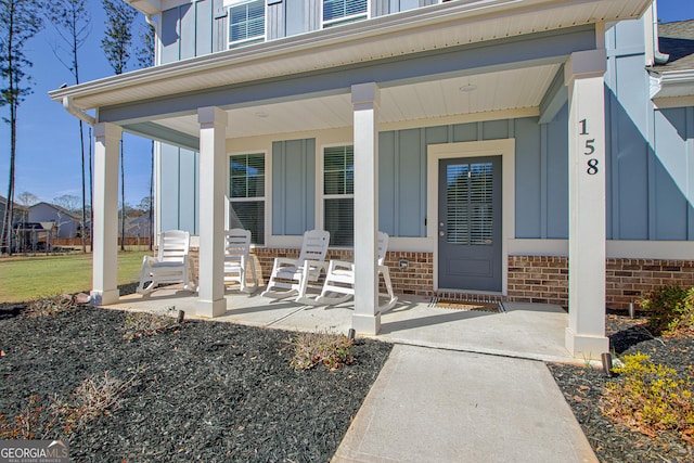 property entrance with covered porch and board and batten siding