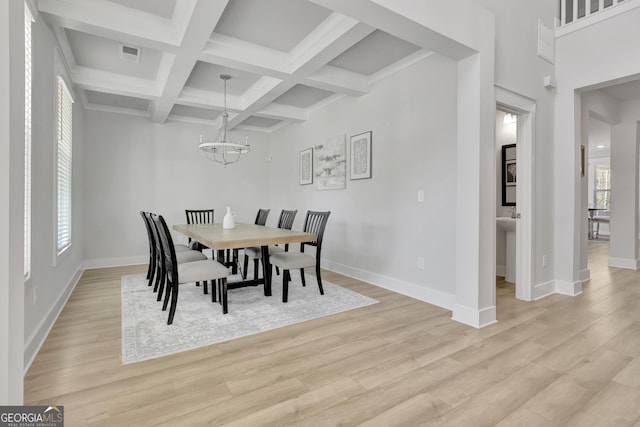 dining area with light wood-style flooring, visible vents, a chandelier, and beam ceiling