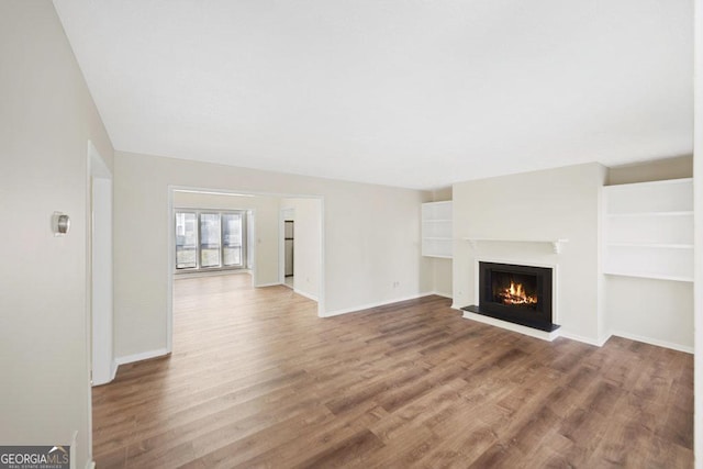 601 Park Ridge Cir, Marietta, GA 30068 - unfurnished living room featuring a warm lit fireplace and wood finished floors