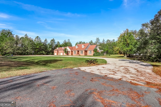 view of front of home with a garage, a front lawn, and aphalt driveway