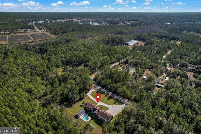 drone / aerial view with a wooded view