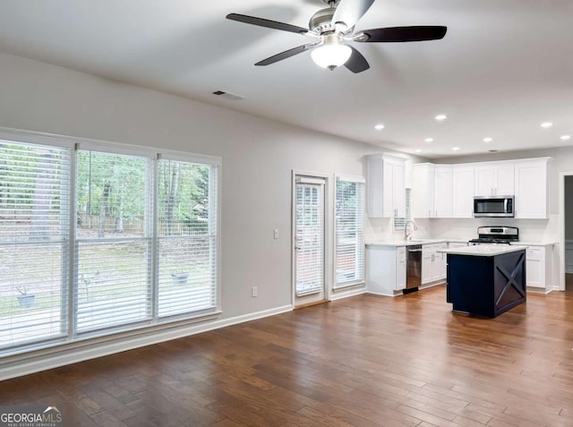 kitchen featuring white cabinetry, appliances with stainless steel finishes, light countertops, and wood finished floors