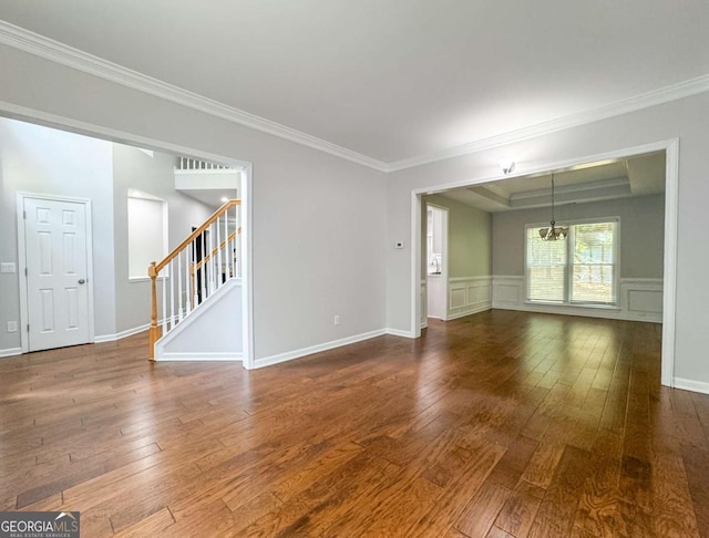 unfurnished living room featuring ornamental molding, dark wood-style flooring, and stairs