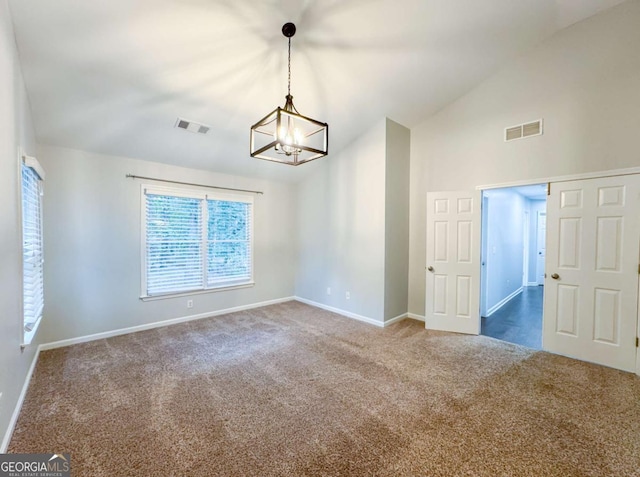 carpeted empty room featuring high vaulted ceiling, baseboards, visible vents, and a notable chandelier