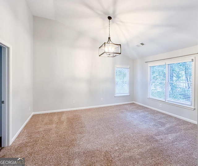 carpeted empty room with a chandelier, visible vents, vaulted ceiling, and baseboards