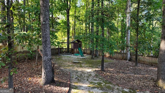 view of yard with a fenced backyard and a playground