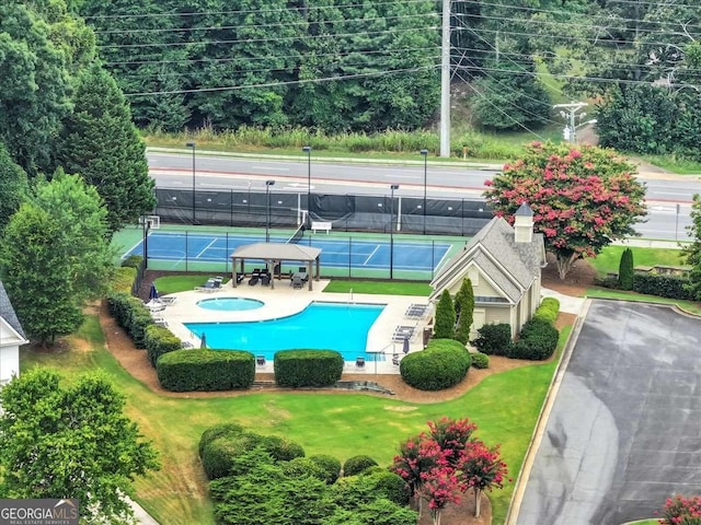 view of pool featuring a tennis court, fence, and a lawn