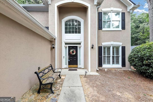 entrance to property featuring stucco siding