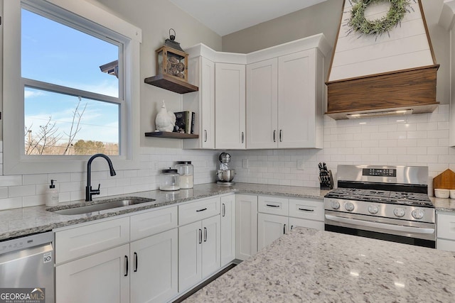 kitchen with decorative backsplash, white cabinets, stainless steel appliances, open shelves, and a sink