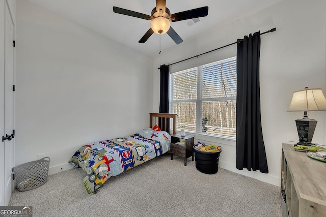 carpeted bedroom with lofted ceiling, visible vents, and a ceiling fan