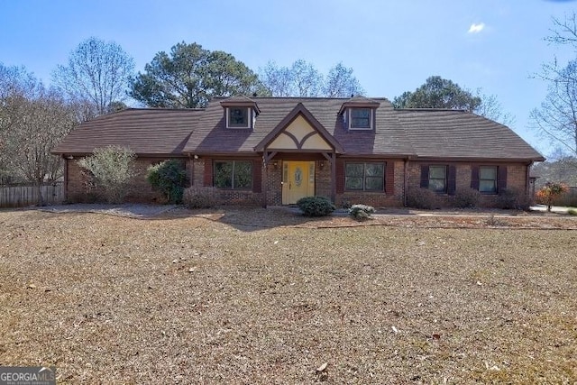 tudor house with a front yard and brick siding