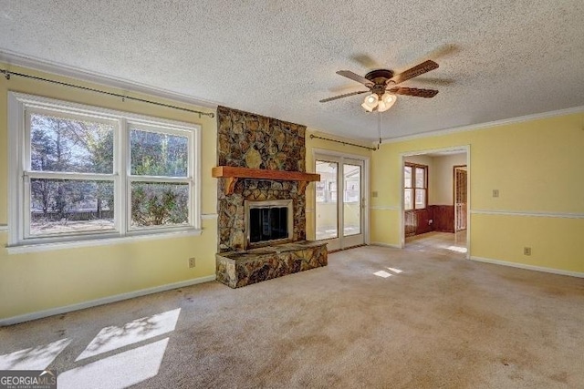 unfurnished living room with a textured ceiling, ceiling fan, a fireplace, and light carpet