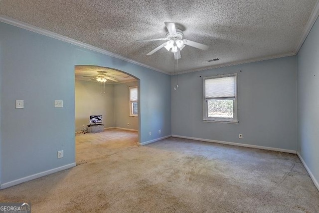 empty room with arched walkways, a textured ceiling, light carpet, visible vents, and ornamental molding