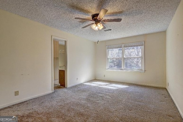 spare room featuring baseboards, visible vents, a ceiling fan, light colored carpet, and a textured ceiling