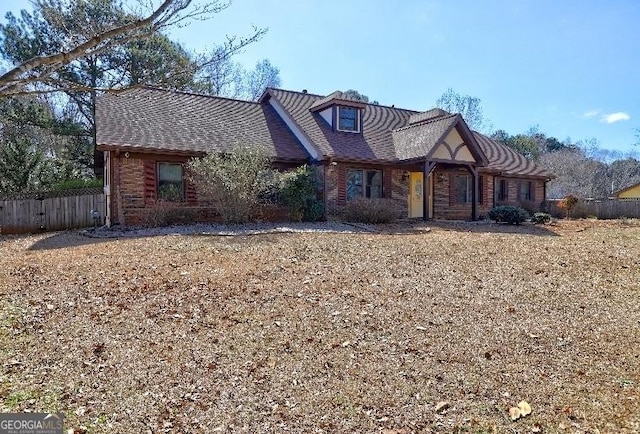 view of front of home with fence and brick siding