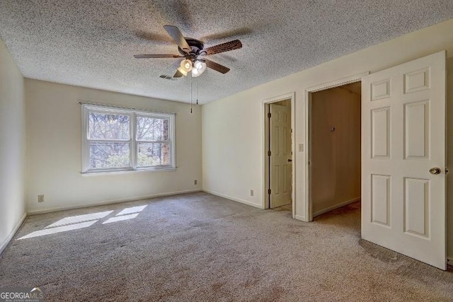 unfurnished bedroom with ceiling fan, a textured ceiling, light carpet, visible vents, and baseboards