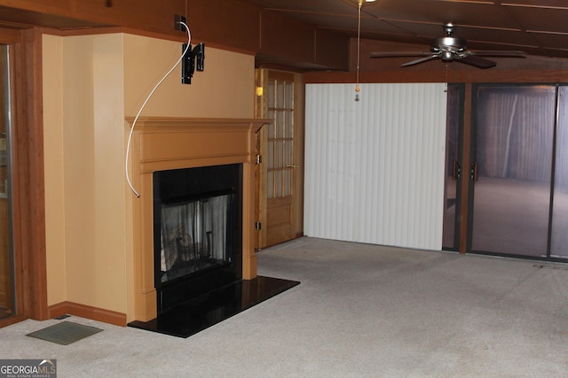 unfurnished living room featuring a fireplace with raised hearth and carpet