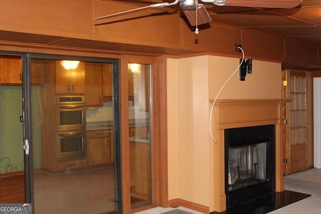 interior space with a fireplace and a ceiling fan