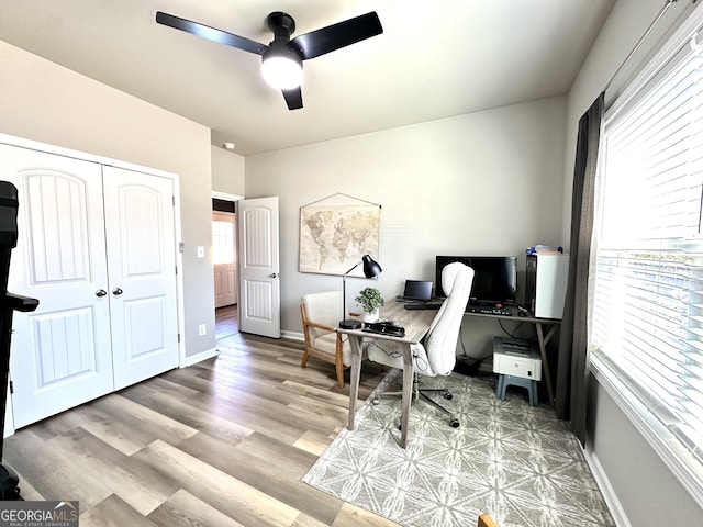 office area featuring wood finished floors, a ceiling fan, and baseboards