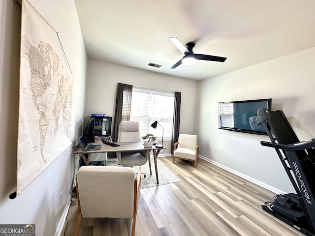 office with light wood-style floors, baseboards, visible vents, and a ceiling fan