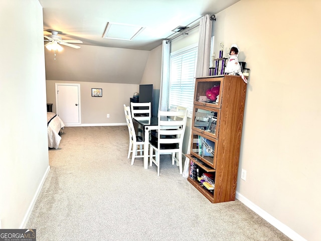 carpeted dining room featuring ceiling fan, attic access, baseboards, and vaulted ceiling