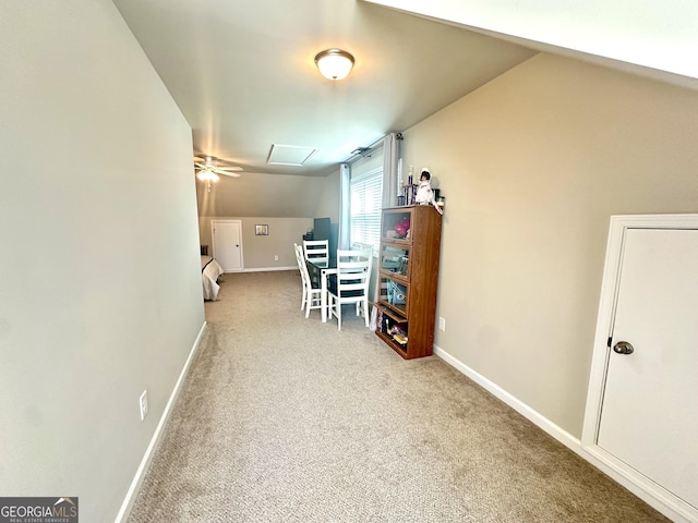 hall with carpet flooring, attic access, and baseboards