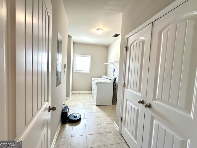 washroom featuring light tile patterned flooring, laundry area, visible vents, baseboards, and washing machine and clothes dryer