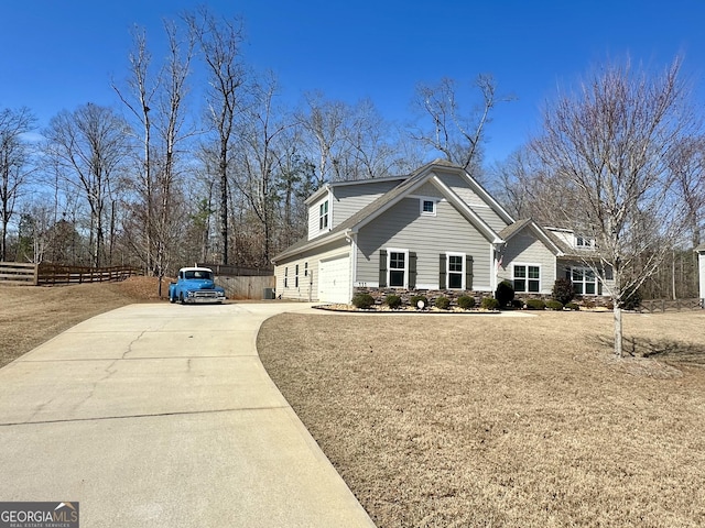 view of front of property with a garage, concrete driveway, and fence