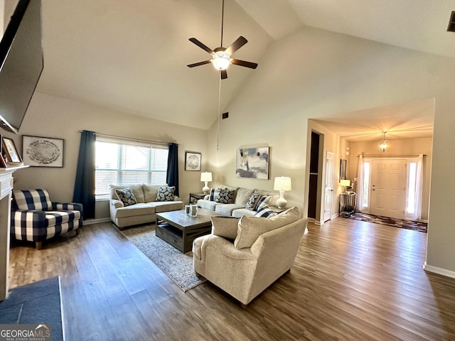 living area featuring high vaulted ceiling, dark wood-type flooring, a fireplace, a ceiling fan, and baseboards