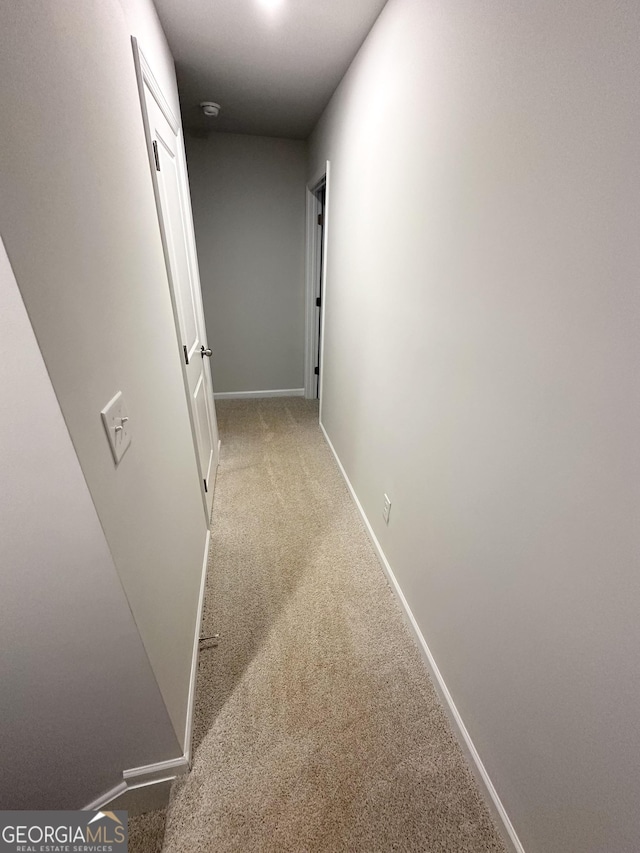 hallway featuring carpet floors and baseboards