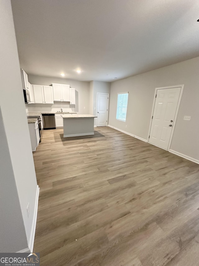 unfurnished living room with light wood-style flooring and baseboards