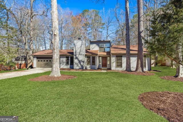 view of front of house featuring a front yard, concrete driveway, a chimney, and an attached garage