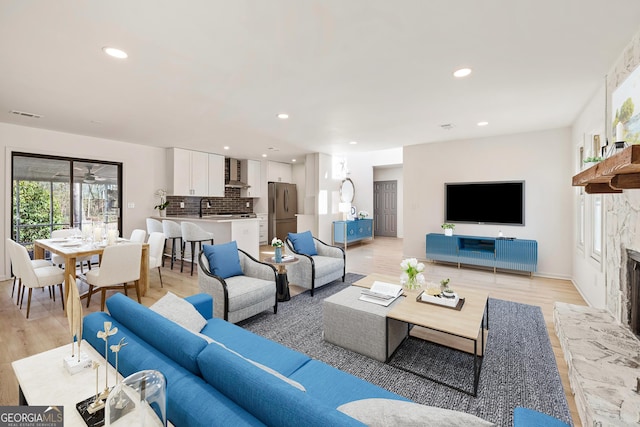 living room with recessed lighting, visible vents, a fireplace, and light wood finished floors