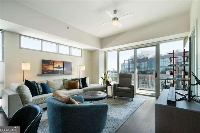 living room with ceiling fan, wood finished floors, and a city view