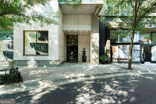 doorway to property featuring stucco siding