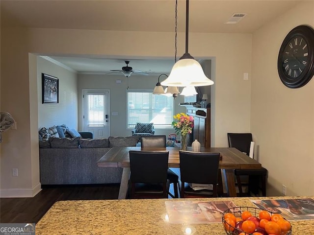 dining area with dark wood-type flooring, visible vents, ceiling fan, and baseboards