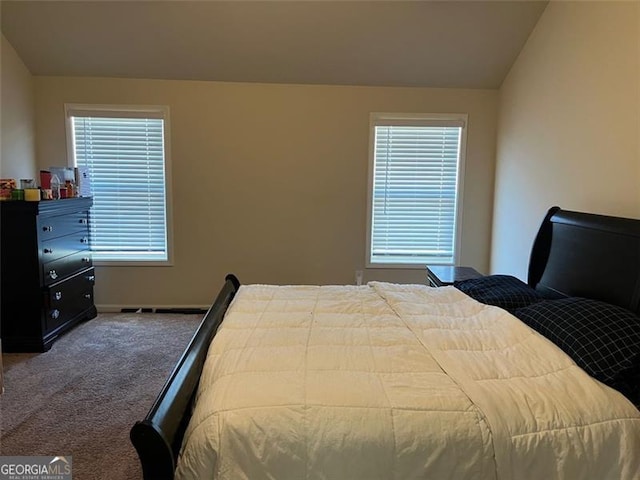 bedroom featuring lofted ceiling and carpet