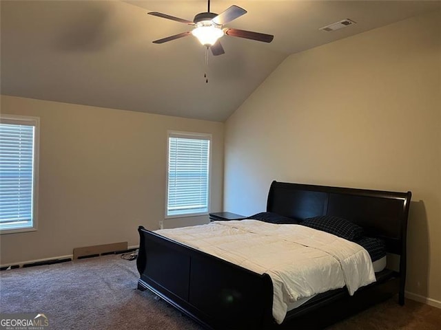 bedroom featuring lofted ceiling, baseboards, multiple windows, and dark colored carpet