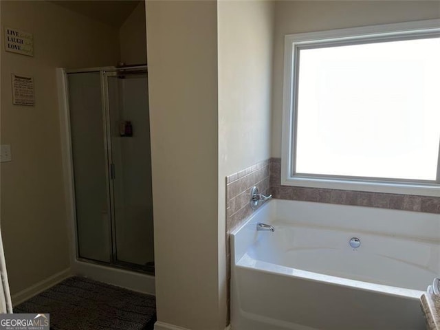 full bath featuring a shower with door and a bath