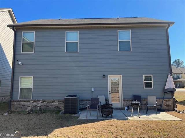 rear view of house featuring central air condition unit, a yard, an outdoor fire pit, and a patio