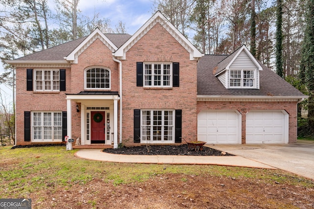 view of front of house with a shingled roof, concrete driveway, brick siding, and an attached garage