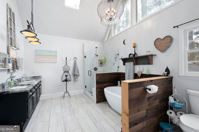 full bathroom with double vanity, toilet, a sink, a shower stall, and a freestanding tub