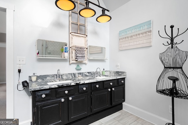 interior space with a sink, baseboards, and double vanity
